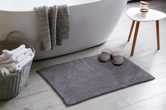 Badezimmer mit Badematte und Hausschuhen